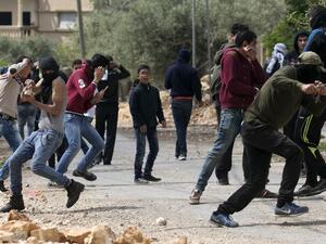 Palestinian protesters take cover during clashes with Israeli security forces following a weekly demonstration against the expropriation of Palestinian land by Israel in the village of Kfar Qaddum, near Nablus, in the occupied West Bank on April 14, 2017. (AFP/Jaafar Ashtiyeh)