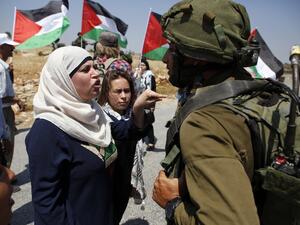Demonstrators protest before Israeli forces West Bank village of Nabi Saleh, north of Ramallah, on May 12, 2017, after a demonstration following Friday prayers in solidarity with Palestinian prisoners on hunger strike in Israeli jails. (AFP/Abbas Momani)