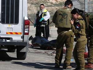 Israeli forces stand next to the body of a Palestinian who was shot dead following an alleged attempt to stab Israeli border police, at a checkpoint near the Israeli settlement of Har Homa in the occupied West Bank. (AFP/File) 