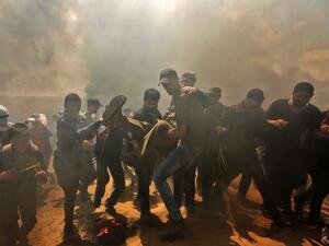 Palestinians carry a demonstrator injured during clashes with Israeli forces near the border between the Gaza strip and Israel east of Gaza City on May 14, 2018. (MAHMUD HAMS / AFP)