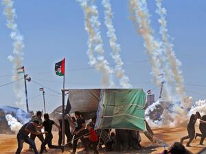 Palestinians run for cover from tear gas near the border between Israel and the Gaza Strip, east of Jabalia. (Mohammed ABED/ AFP)