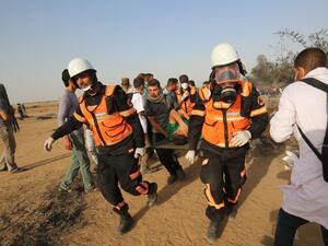Palestinian medics evacuate a wounded protester during clashes with Israeli forces along the border with the Gaza strip east of Khan Yunis on May 18, 2018. (SAID KHATIB / AFP)
