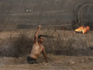 Disabled Palestinian Saber al Ashqar, aged 29, uses a slingshot to throw stones at Israeli forces during a demonstration near the border with Israel, east of Gaza City, on October 19, 2018. (MAHMUD HAMS / AFP)