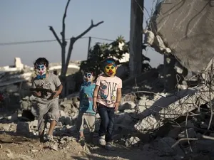 Palestinian children play in the rubble of buildings, reportedly destroyed during the 50-day war between Israel and Hamas militants. (AFP / MOHAMMED ABED)
