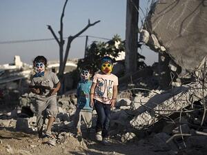 Palestinian children play in the rubble of buildings, reportedly destroyed during the 50-day war between Israel and Hamas militants. (AFP / MOHAMMED ABED)