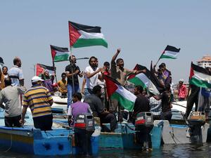 Palestinians rally, Tuesday, in the port of Gaza in support of a flotilla that aimed to break the blockade ( AFP/ File photo)