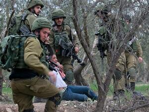 Israeli forces arrest a young Palestinian protester near the Huwara checkpoint, south of Nablus, in the Israeli-occupied West Bank. (AFP/ File)