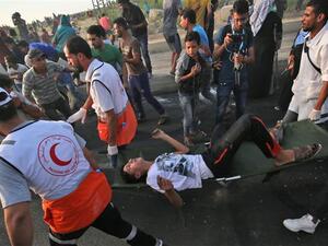 Palestinian paramedics carry an injured man as protesters demonstrate in the northern Gaza Strip on October 3, 2018. (AFP/File)