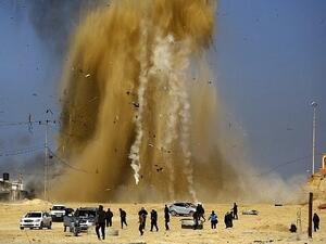 Palestinians run for cover as sand and smoke rise following an Israeli airstrike on a Hamas post in the northern Gaza Strip. (Mohammed Abed/ AFP)