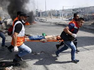 Palestinian medics carry away a protester who was injured during clashes with Israeli security forces in the West Bank city of Qalandiya, north of Jerusalem. (Abbas Momani/ AFP)
