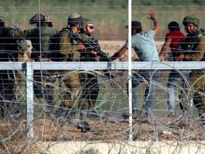 Israeli soldiers arrest Palestinians who tried to approach the Gaza fence during clashes east of Gaza City on May 15, 2018. (AFP/ File Photo)