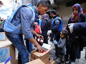 Palestinians gather at an UNRWA aid distribution. (AFP/File)