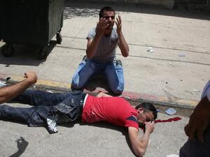 A man reacts next to the body of a young Palestinian protester shot dead on Thursday (Jaafar Ashtiyeh/AFP)