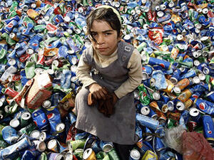 An Iraqi girl from an impoverished family searches through garbage for recyclable items at a waste dump on the outskirts of the shrine city of Najaf. (AFP/file)