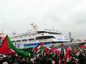 People wave Palestinian and Turkish flags as they welcome the Mavi Marmara ship at Istanbul's Sarayburnu port on December 26, 2010. The Turkish ferry which was the target of a deadly raid by Israeli commandos when it tried to deliver aid to Gaza received a rapturous welcome from thousands on Sunday as it arrived back in Istanbul. 