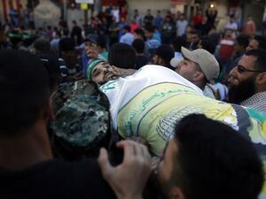 Palestinian mourners carry the body of man who was killed during clashes with Israeli soldiers, on May 14, 2018 in Gaza City/AFP