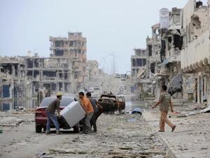 This file photo taken on October 24, 2011 shows Libyans load their belongings into a car in a destroyed street in Sirte. (AFP/File) This file photo taken on October 24, 2011 shows Libyans load their belongings into a car in a destroyed street in Sirte. (AFP/File)