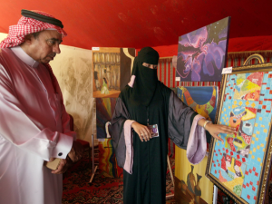 A Saudi woman examines a piece of artwork at a gallery showing. (AFP/File)
