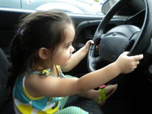 Little girl takes the wheel after father leaves car running. [blogspot]