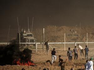 Palestinian protesters throw stones towards Israeli forces during a demonstration along the border between Israel and the Gaza strip, east of Gaza city on July 27, 2018. (MAHMUD HAMS / AFP)