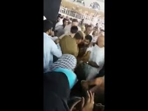 The man is rushed away from the Kaaba on Monday (screenshot)