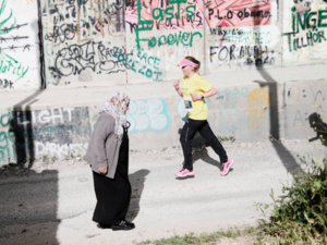 A runner passes the Wall while participating in the Bethlehem Marathon (Facebook / Right to Movement)