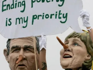 Demonstrators in face masks of world politicians carrying their slogans.
