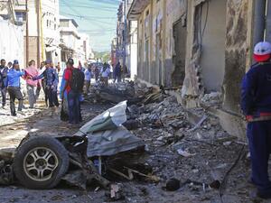 Somali security forces and civilians gather at the scene of a car bomb attack in Mogadishu on May, 15, 2017 (Mohamed Abdiwahab/AFP)
