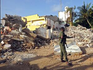 A Somali soldier stands guard on June 26, 2016 on the scene of the attack on a hotel in Mogadishu that killed 15 people the day before and was claimed by al-Shabaab militants. (AFP/Mohamed Abdiwahab)