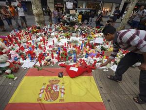 A man displays a candle to pay tribute to the victims of the attack on Las Ramblas boulevard (AFP)