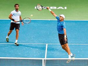 Horia Tecau powers a smash as his partner Jean-Julien Rojer watches during their men’s doubles final against Rohan Bopanna and Marcin Matkowski atDubai Tennis Stadium. (Photo: Ahmed Ramzan/Gulf News)