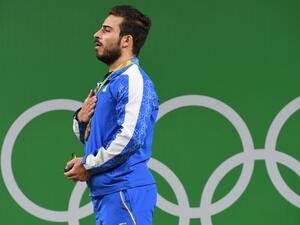 Iran's gold medallist Kianoush Rostami poses on the podium after the men's weightlifting 85kg event during the Rio 2016 Olympics Games in Rio de Janeiro on August 12, 2016.
GOH Chai Hin / AFP
