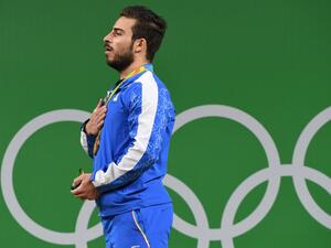 Iran's gold medallist Kianoush Rostami poses on the podium after the men's weightlifting 85kg event during the Rio 2016 Olympics Games in Rio de Janeiro on August 12, 2016.
GOH Chai Hin / AFP