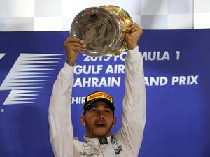 Mercedes AMG Petronas British driver Lewis Hamilton celebrates with his trophy on the podium after winning the Formula One Bahrain Grand Prix at the Sakhir circuit in the desert south of the Bahraini capital, Manama, on April 19, 2015. AFP PHOTO / MARWAN NAAMANI
MARWAN NAAMANI / AFP