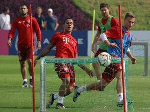 Bayern Munich's German midfielder Joshua Kimmich (R) scores past Spanish midfielder Thiago Alcantara (C) during a training session as part of the team's winter training camp in the Qatari capital Doha on January 10, 2016. KARIM JAAFAR / AFP
