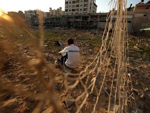 Palestinian runner and football player Bilal Abu Samaan, 20, sits in the rubble of the bombed Palestine Stadium in Gaza City on November 28, 2012. The stadium was bombed by the Israeli airforce during a conflict between the ruling Hamas party and the Israeli military between 14 and 21 November 2012. AFP PHOTO / PATRICK BAZ
PATRICK BAZ / AFP