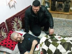 Late Iranian wrestler Nasser Hosseinpour rests as Iranian wrestler and two-time World Champion Reza Yazdani visits him at his house in the city of Juybar, northern Iran, in this undated picture. (Photo: Press TV)