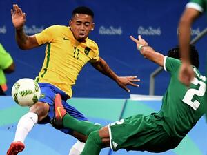 Brazil's player Gabriel Jesus (L) and Iraq's Dhurgham Ismael vie for the ball during their Rio 2016 Olympic Games Men's First Round Group A football match, at the Mane Garrincha Stadium in Brasilia on August 7, 2016.
EVARISTO SA / AFP