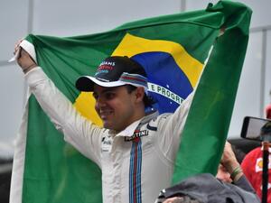 Williams Martini Racing's Brazilian driver Felipe Massa, holding his country's flag, greets fans after his final appearance at Interlagos circuit before retirement, at the end of the Brazilian Grand Prix in Sao Paulo, Brazil, on November 13, 2016.
Nelson Almeida / AFP