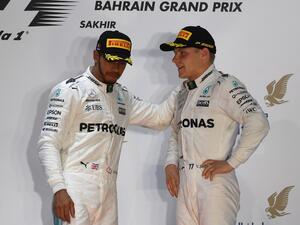 Mercedes' British driver Lewis Hamilton (L) and Mercedes' Finnish driver Valtteri Bottas stand on the podium after Ferrari's German driver Sebastian Vettel won the Bahrain Formula One Grand Prix at the Sakhir circuit in Manama on April 16, 2017.
ANDREJ ISAKOVIC / AFP