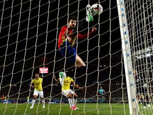 جيرارد بيكيه مدافع برشلونة يحاول إبعاد الكرة التي جاء منها هدف كولومبيا الأول