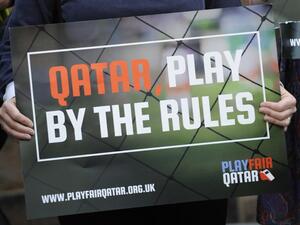 A demonstrator holds a placard critical of Qatar's policies regarding the working conditions of migrant workers in light of the increased construction to provide the infrastructure for the Gulf state to host the FIFA World Cup in 2022. AFP PHOTO / ANDY BUCHANAN
Andy Buchanan / AFP