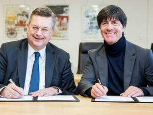 لوف (يمين) يوقع على عقد استمراره مع ألمانيا