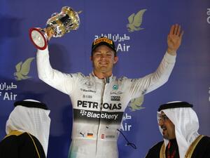 Mercedes AMG Petronas German driver Nico Rosberg holds up his trophy as he celebrates on the podium after taking third place in the Formula One Bahrain Grand Prix at the Sakhir circuit in the desert south of the Bahraini capital, Manama, on April 19, 2015. AFP PHOTO / MARWAN NAAMANI
MARWAN NAAMANI / AFP