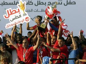 Players of Shabab Rafah football club celebrate their team's victory in the 2017 edition of the Gaza Cup at Yarmouk Stadium in Gaza City on May 12, 2017.
MAHMUD HAMS / AFP