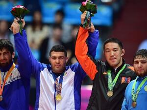 Gold medalist Iran's Reza Yazdani (2nd L) poses with silver medalist Kyrgyzstan's Magomed Musaev (L) and bronze medalists Mongolia's Khuderbulga Dorjkhand (2nd R) and Kazakhstan's Mamed Ibragimov (R) in the medal ceremony of the men's freestyle 97 kg wrestling event during the 2014 Asian Games at the Dowon Gymnasium in Incheon on September 28, 2014. AFP PHOTO / JUNG YEON-JE
JUNG YEON-JE / AFP