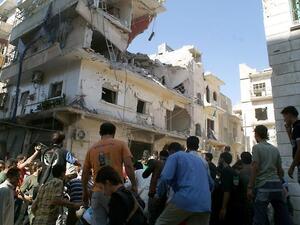 Rescuers and neighboors gather at the scene after a rocket slammed into the side of a residential building in the northern city of Aleppo, on June 29 (Jalal Al-Halabi / AFP)