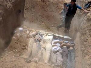 SYRIA, DAMASCUS : An image grab taken from a video uploaded on YouTube by the Local Committee of Arbeen on August 21, 2013 allegedly shows Syrians covering a mass grave containing bodies of victims that Syrian rebels claim were killed in a toxic gas attack by pro-government forces in eastern Ghouta and Zamalka, on the outskirts of Damascus. AFP PHOTO / YOUTUBE / LOCAL COMMITTEE OF ARBEEN