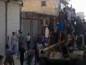 حلبيون يعتلون ظهر دبابة استولىعليها مقاتلون من المعارضة/أ.ف.ب