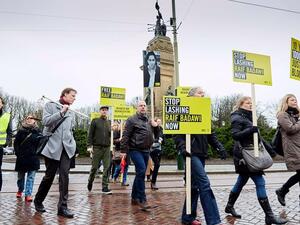 Demonstrators from Amnesty International, a human rights watchdog, protest flogging of jailed Saudi blogger Raif Badawi in front of the Saudi embassy in the Hague.  (AFP/File)